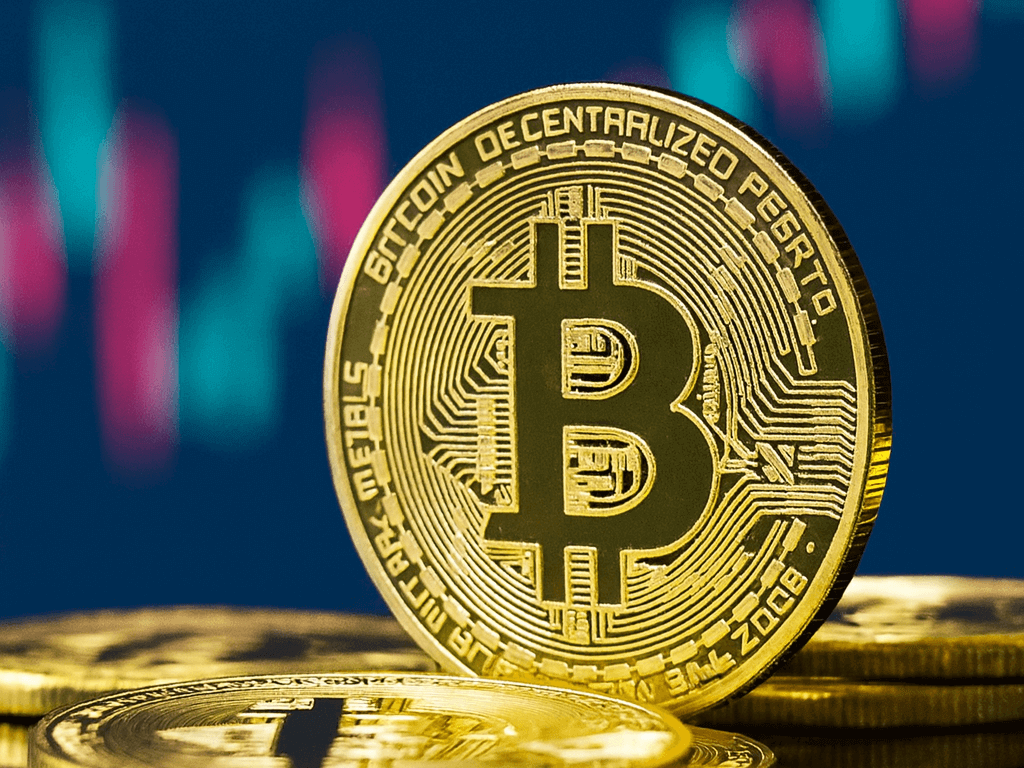 비트코인이란 무엇인가
B 가 적인 금화가 놓여져있고 뒤로는 차트가 흐릿하게 보이는 모습